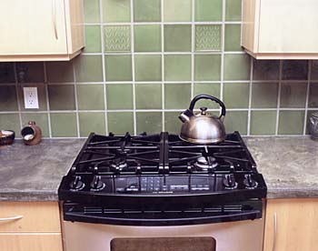 celadon tile backsplash with olive leaf cameos